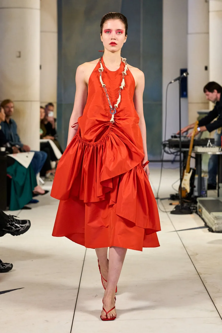 SHOWstudio, Litkovska S/S 27 STRICHA: a model in a red ruffled halter dress with a long necklace on the runway